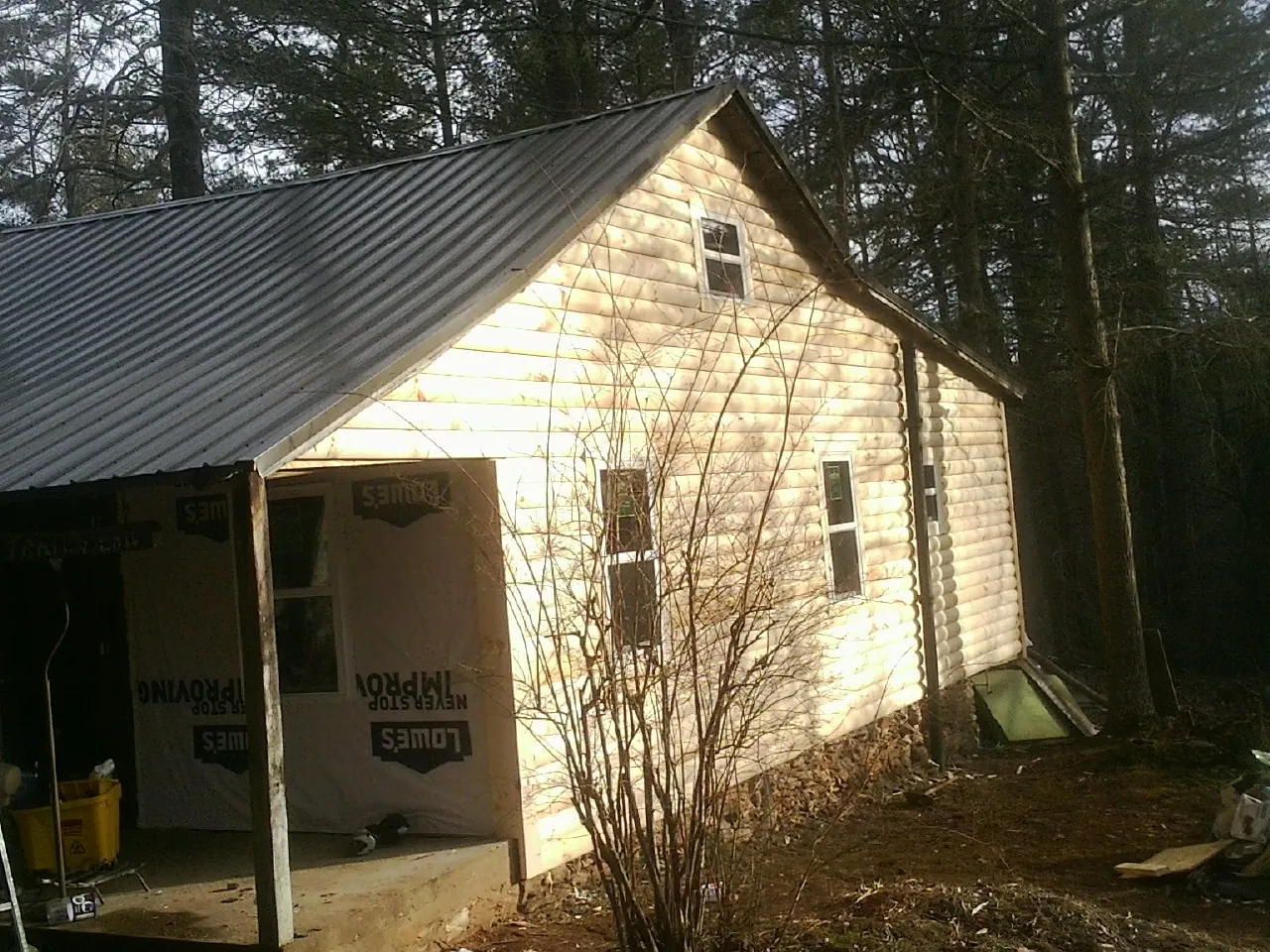 Log siding gable end under a dark metal roof edge in Kootenai