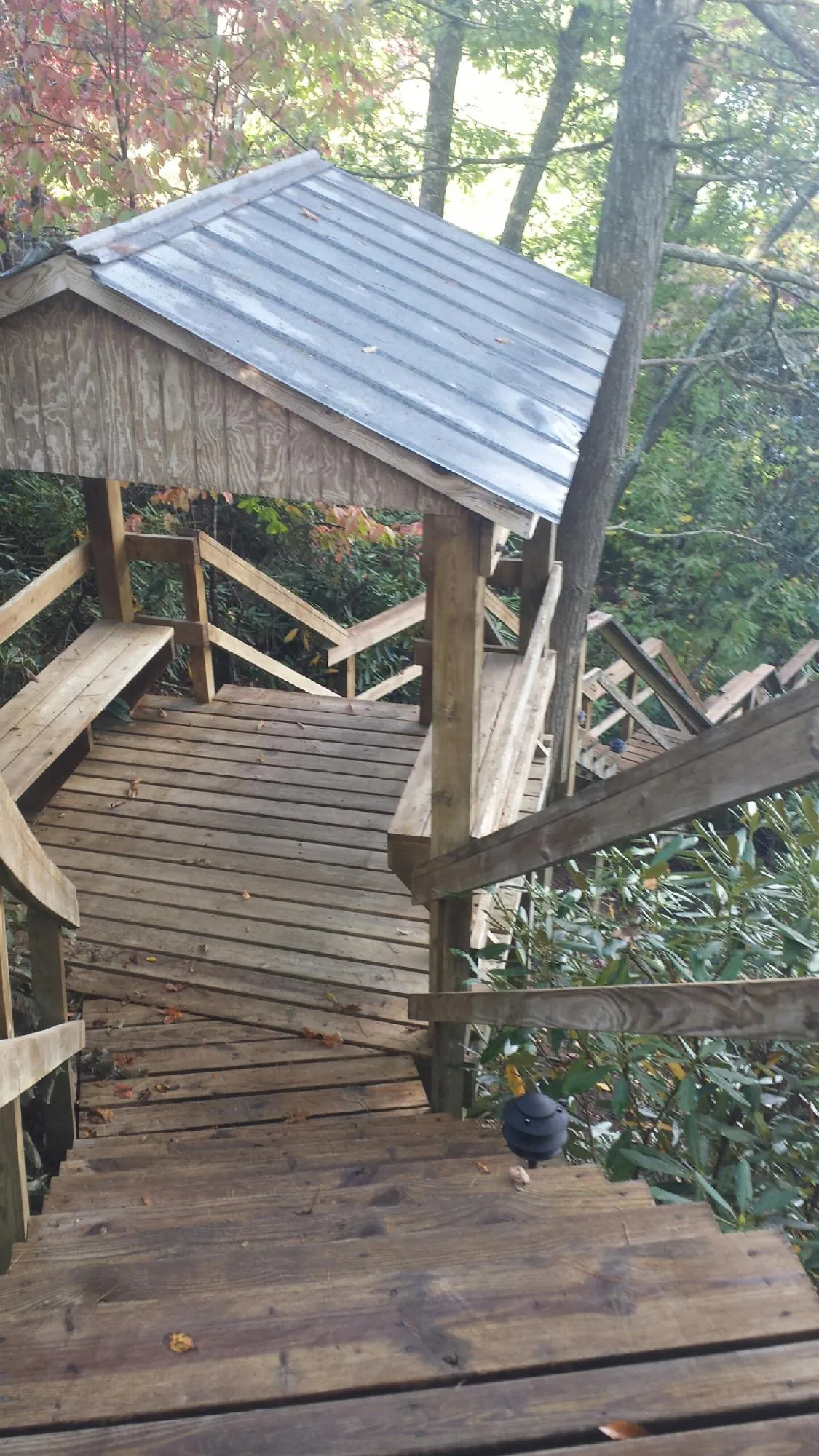 Metal roofed shelter over wooden steps on a wooded walkway — Skylight Repair & Installation work by our crew in Kootenai
