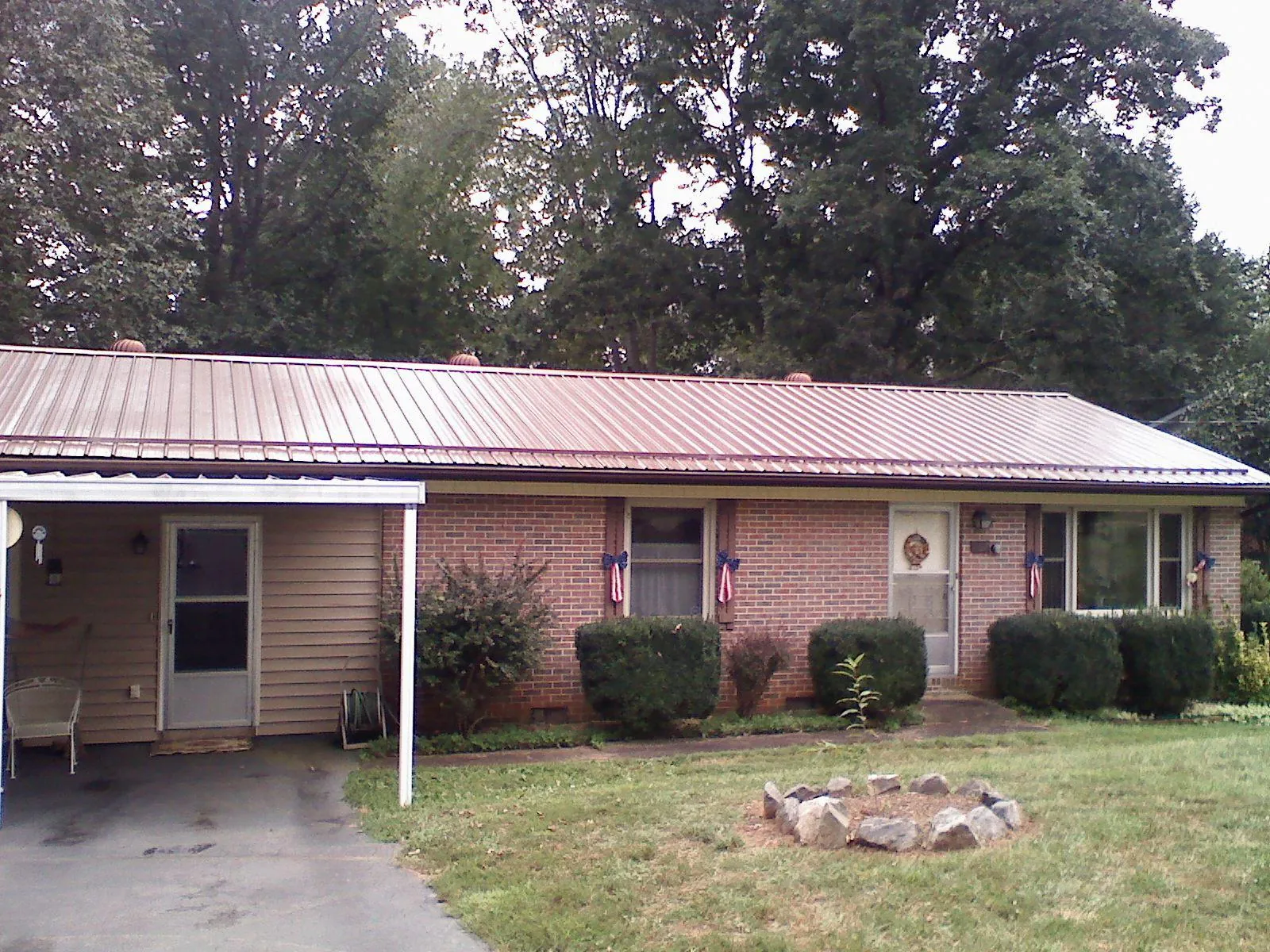 Bronze metal roof and carport on a brick ranch home — Roof Repair work by our crew in Kootenai